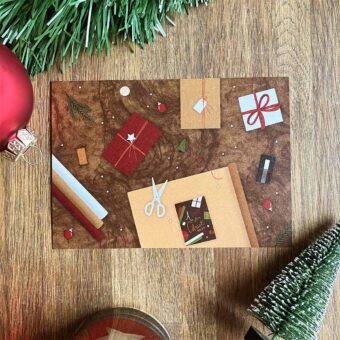 Kerstkaart met inpakpapier en cadeaus op tafel